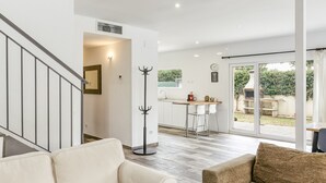 Een modern interieur met een trap, een eetgedeelte en uitzicht op de omgeving.