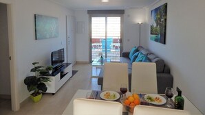 Un soggiorno moderno con zona pranzo, televisore e balcone con vista.