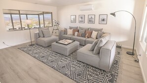 A modern living room with a large window, a telescope, and a sofa set.