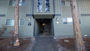 A two-story building with a central entrance and a staircase leading to the upper floor.