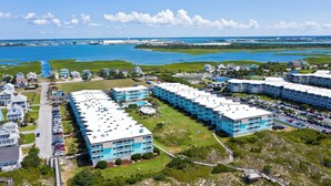 Et kysthotel med flere blå bygninger, parkeringsområder og udsigt over havet.