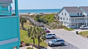 Un hôtel situé sur la côte, doté d’un parking, d’un escalier menant à la plage et offrant une vue sur l’océan.