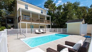 A two-story building with a swimming pool and outdoor seating area. - Shangri La, Oceanside House in Emerald Isle, NC! (Emerald Isle)