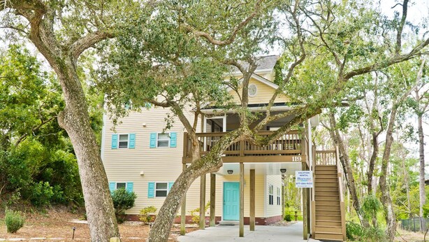 A two-story building with a covered porch and a staircase leading to the entrance. - Shangri La, Oceanside House in Emerald Isle, NC! (Emerald Isle)