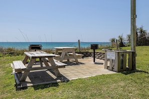 A picnic area with tables and benches, a trash can, and a sign indicating no trash allowed. - Summer Winds B-135, Oceanfront Condo in Indian Beach, NC! (Indian Beach)