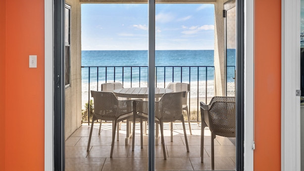 A balcony with a view of the ocean, a table, and four chairs. - Summer Winds 221, Oceanfront Condo in Indian Beach, NC! (Indian Beach)