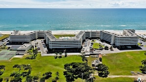 A multi-story hotel with a parking lot and a view of the ocean. - Summer Winds B-235, Oceanfront Condo in Indian Beach, NC! (Indian Beach)