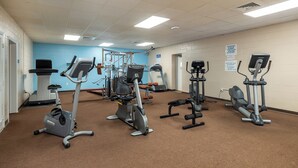 Ein Fitnessstudio mit Laufbändern, Crosstrainern und Krafttrainingsgeräten.