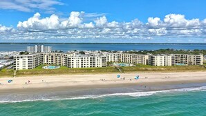 A beachfront hotel with multiple buildings, a sandy beach, and a clear view of the ocean. - Summer Winds A-415, Oceanfront Condo in Indian Beach, NC! (Indian Beach)