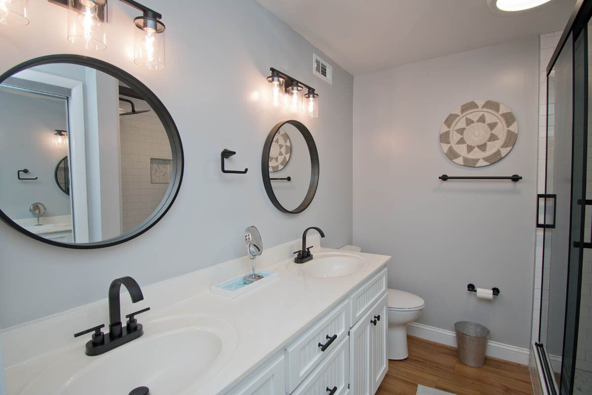 Un baño moderno con tocador doble, inodoro y zona de ducha.