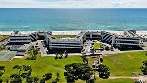 A multi-story hotel with a parking lot and a view of the ocean. - Summer Winds A-505, Oceanfront Condo in Indian Beach, NC! (Indian Beach)
