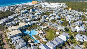 Vue aérienne de George's, situé à Aly's Beach, avec une grande piscine, de nombreux bâtiments blancs et une plage en arrière-plan.