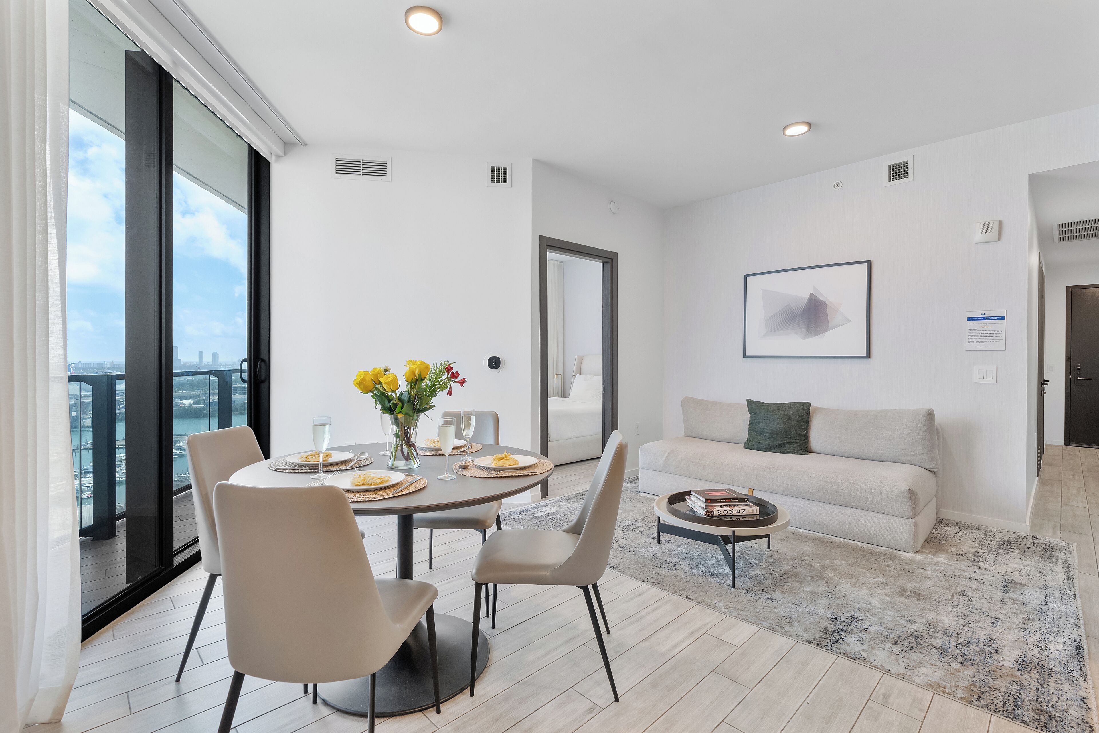 A modern living room with a dining area, a sofa, and a coffee table.