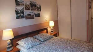 Una camera da letto con un letto, due abat-jour e una serie di quadri appesi al muro.