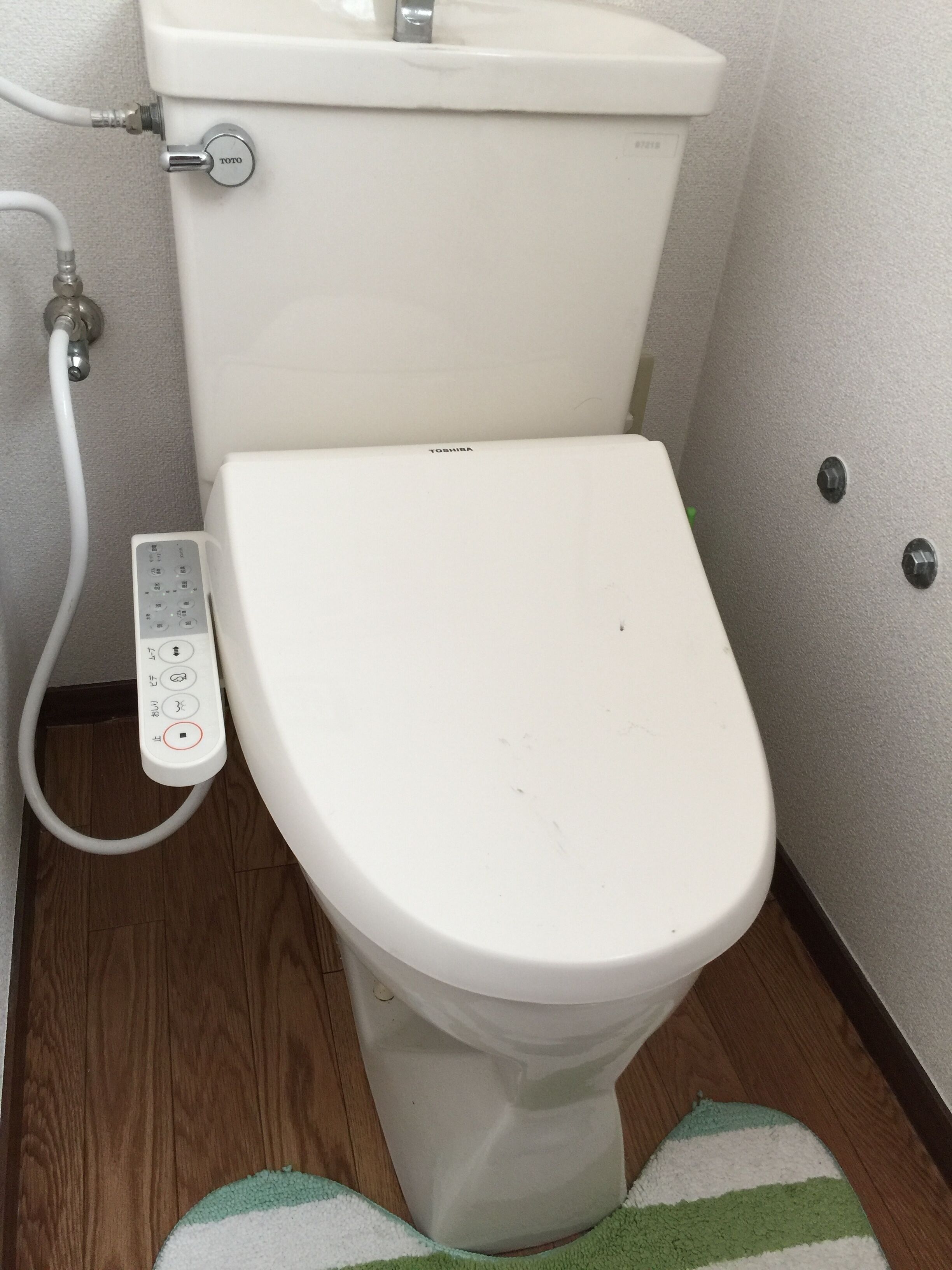Un water bianco con pannello di controllo ed etichetta del marchio TOTO.