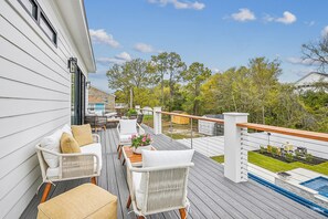 Una terraza con mobiliario exterior, piscina y vistas del entorno.