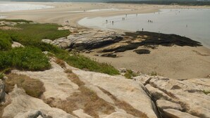 A beach with rocky outcrops and a sandy shore. - Charming, quiet 3-BR cottage; private access to cove and forest trails (Phippsburg)