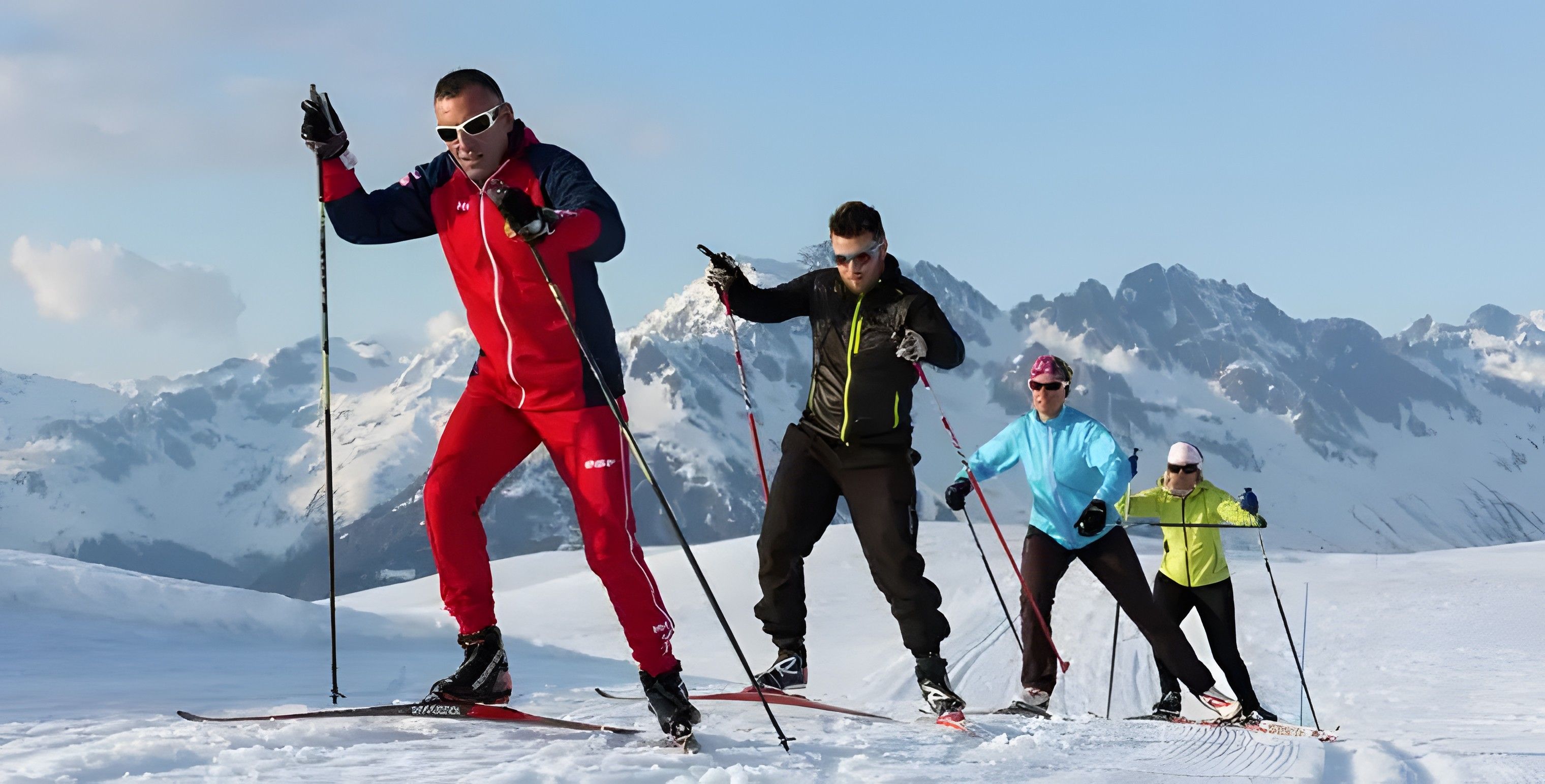 A group of people cross-country skiing on a snowy mountain with a clear sky.