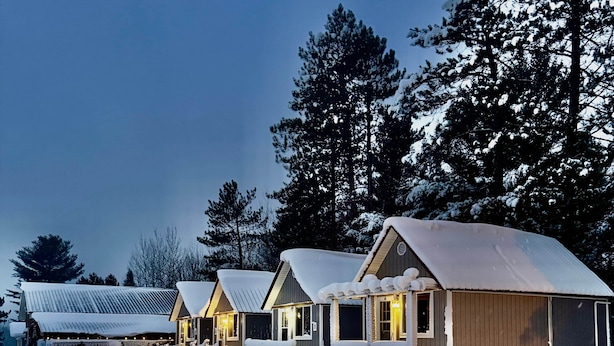 A row of cabins with snow-covered roofs and a path leading to them. - Ruth Lake Resort Cabin # 4 (Spurr Township)