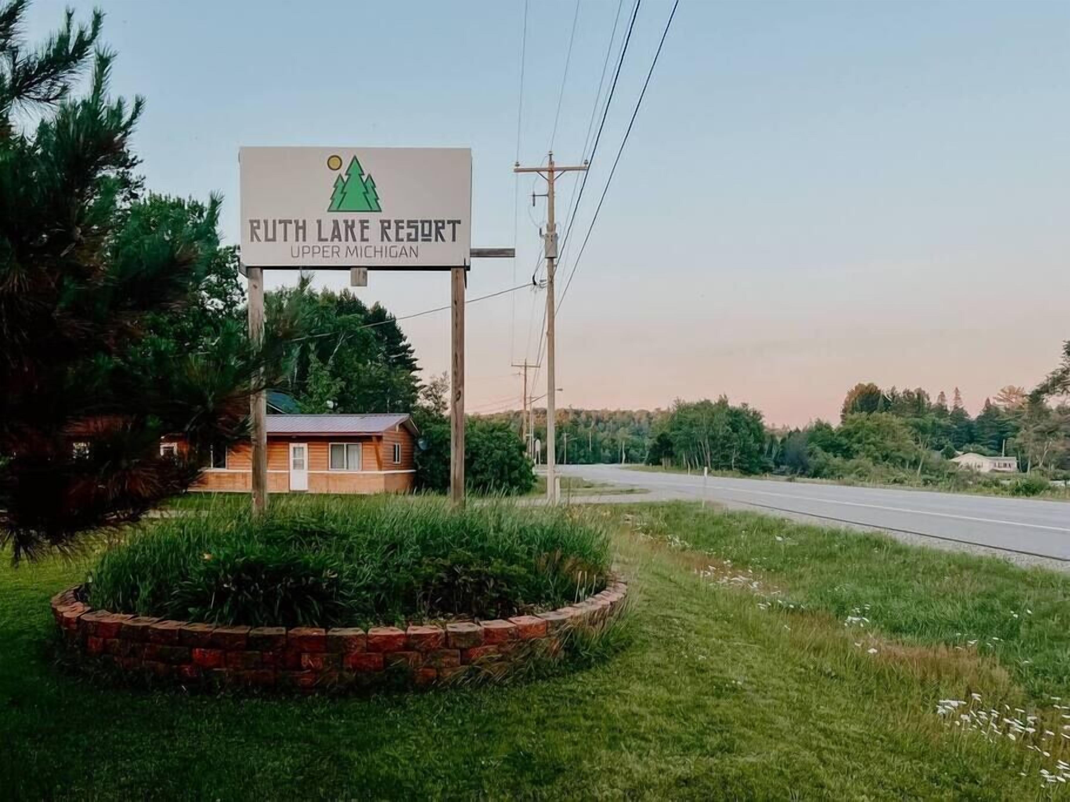 A sign for Ruth Lake Resort in Upper Michigan with a mountain and sun logo.