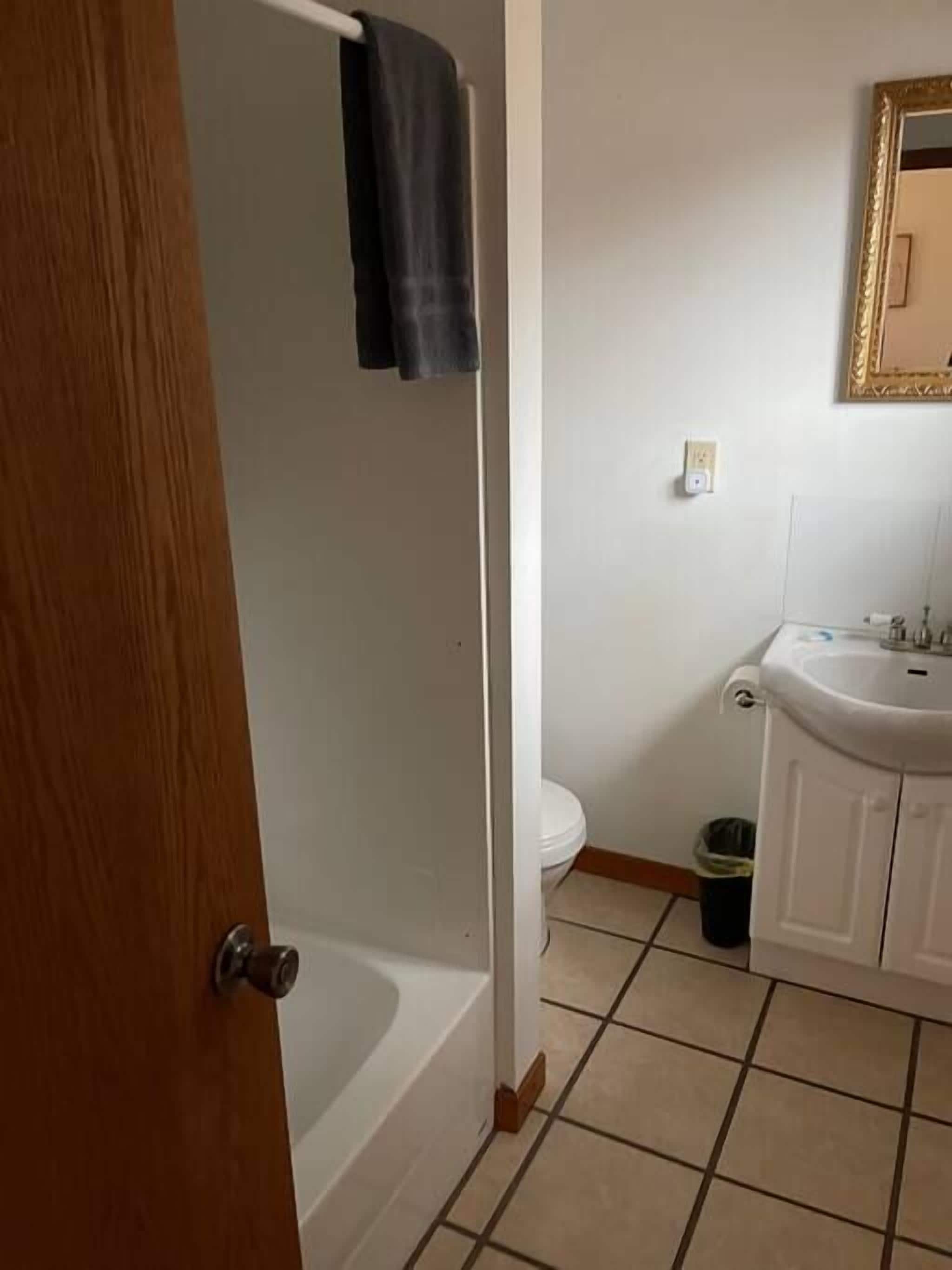 A bathroom with a bathtub, toilet, sink, and a towel rack.