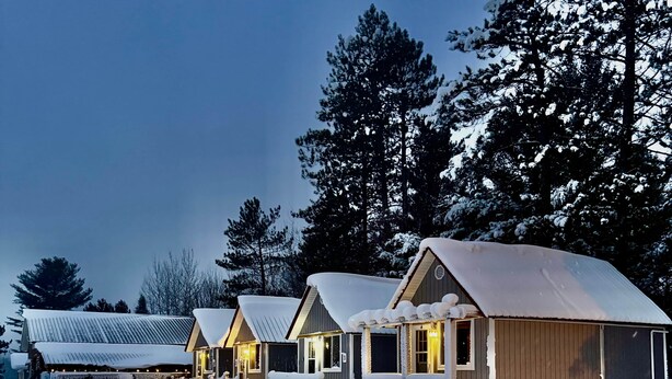 A row of cabins with snow-covered roofs and a path leading to them. - Ruth Lake Resort Cabin #2 (Spurr Township)