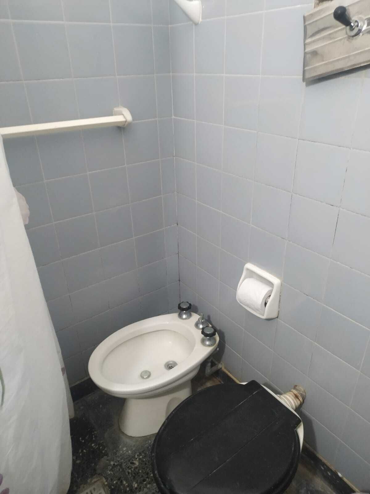 Ein kleines Badezimmer mit Toilette, Bidet und Handtuchhalter.