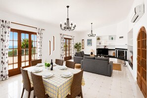 Un amplio espacio habitable con mesa de comedor, sofás y cocina.