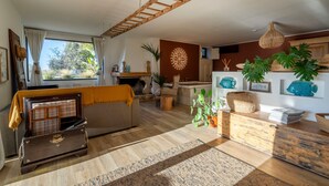 A cozy living room with a sofa, a wooden chest, a fireplace, and a view of the outdoors. - Villa 'Torto' with Private Pool, Wi-Fi, and Air Conditioning (Monopoli)