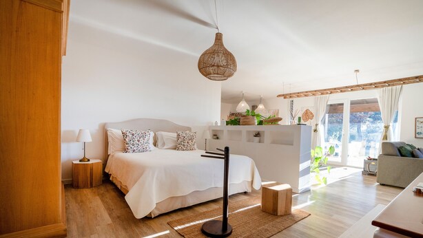 A modern bedroom with a bed, bedside tables, a hanging light fixture, and a view of the outdoors. - Villa 'Torto' with Private Pool, Wi-Fi, and Air Conditioning (Monopoli)