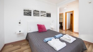 A modern bedroom with a large bed, a nightstand, and a wall-mounted TV. - Villa Dacil - Three Bedroom Villa, Sleeps 6 (Playa Blanca)