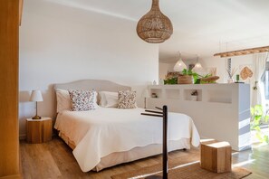 A bedroom with a bed, bedside tables, a hanging light fixture, and a view of the outside. - Villa 'Suite in Torto with Pool', Shared Pool, Wi-Fi & Air Conditioning (Monopoli)
