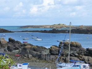 A rocky coastal area with boats anchored near the shore.