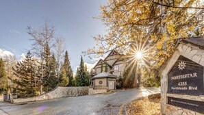 A residential area with a stone sign indicating the address 4355 Northlands Blvd. - Central 2BR with Prime Amenities (Whistler)