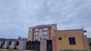 A multi-story building with a curved facade, multiple balconies, and a gated entrance. - Luxury complex at Agric Kumasi (Kumasi)