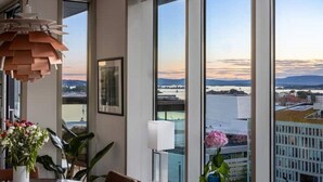 A modern room with large windows, a pendant light, and a view of the cityscape.