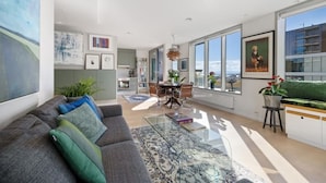 A modern living room with a sofa, coffee table, and dining area.