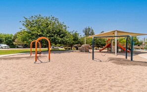 A playground with swings and slides, surrounded by sand and trees. - The Hudson Suite Spot - Studio Apt Close to ASU (Tempe)