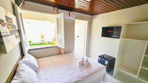 A hotel room with a bed, a TV mounted on the wall, and a window with blinds. - Jf Studio Hotel (São Luís)