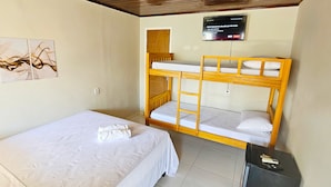 A room with a bunk bed, a single bed, a TV mounted on the wall, and a small desk with a phone. - Jf Studio Hotel (São Luís)
