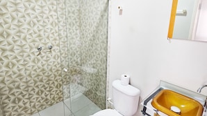 A bathroom with a glass shower enclosure, a white toilet, a yellow sink, and a mirror above the sink. - Jf Studio Hotel (São Luís)