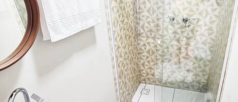 A bathroom with a sink, toilet, and shower.