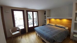 A bedroom with a bed, a chair, and a desk.
