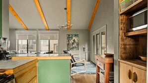 A kitchen with wooden beams, a large island, and a view to the outside. - Moonridge 2BR Ski Oasis (Big Bear Lake)