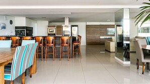 Eine moderne Küche mit Kochinsel, Essbereich mit gestreiften Stühlen und Wohnbereich mit Sofa und Couchtisch.