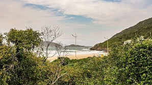 Eine Küstenlandschaft mit Strand, Vegetation und einer Strommast-Konstruktion.
