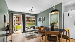 A modern interior with a dining area, sofa, and a view to the outside. - Helt ny Leilighet i Oslo Helsfyr (Oslo)