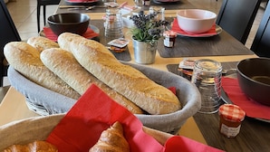 A dining table with bread, condiments, and a knife. - Ferme du Château (Monampteuil)