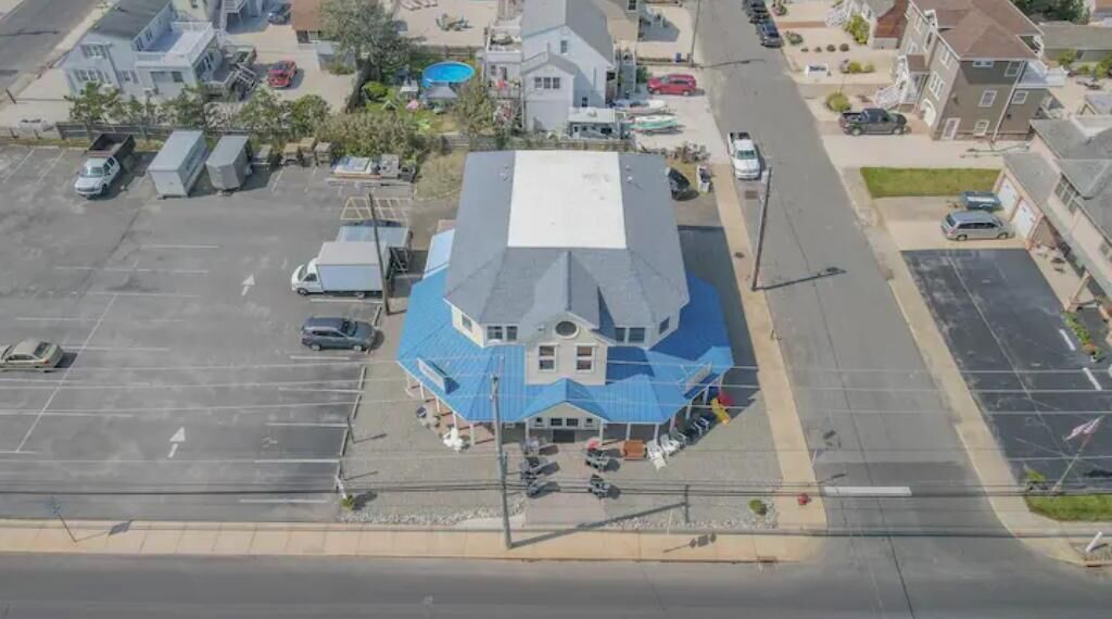 A large building with a blue roof, surrounded by parking lots and other buildings.