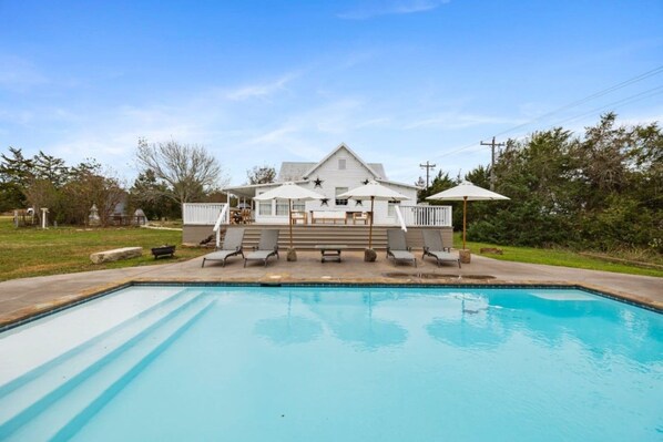 A residential swimming pool with a house in the background. - Round Top charm w/POOL and outdoor dining (Fayette County)
